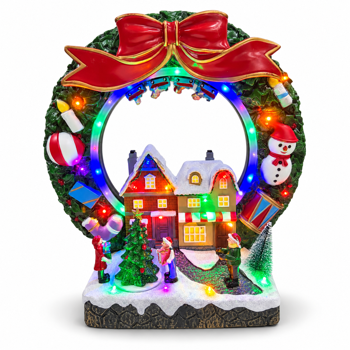 Lighted Christmas village wreath with red bow, snowman, snowy houses and miniature carolers on a white background