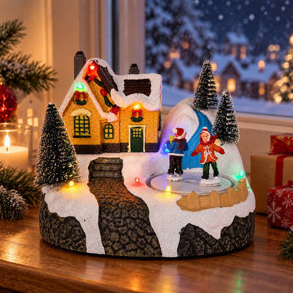 Musical Christmas village skating house with rotating figures, snowy landscape and colorful LED lights
