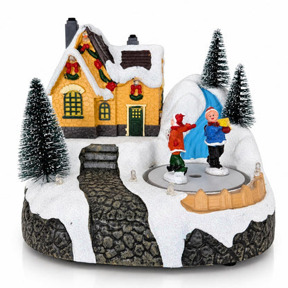 Musical Christmas village skating house with rotating figures, snowy landscape and colorful LED lights
