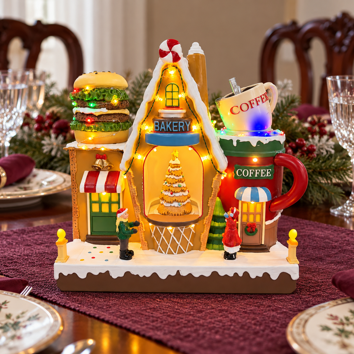 Lighted Christmas bakery and coffee shop on a holiday dining table with burgundy linens and festive place settings